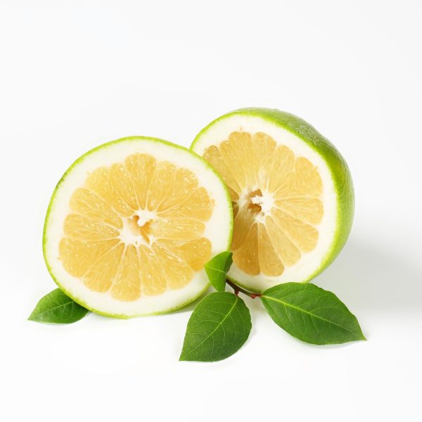 Sliced Oro Blanco Grapefruit with lemon-colored flesh and green leaves.